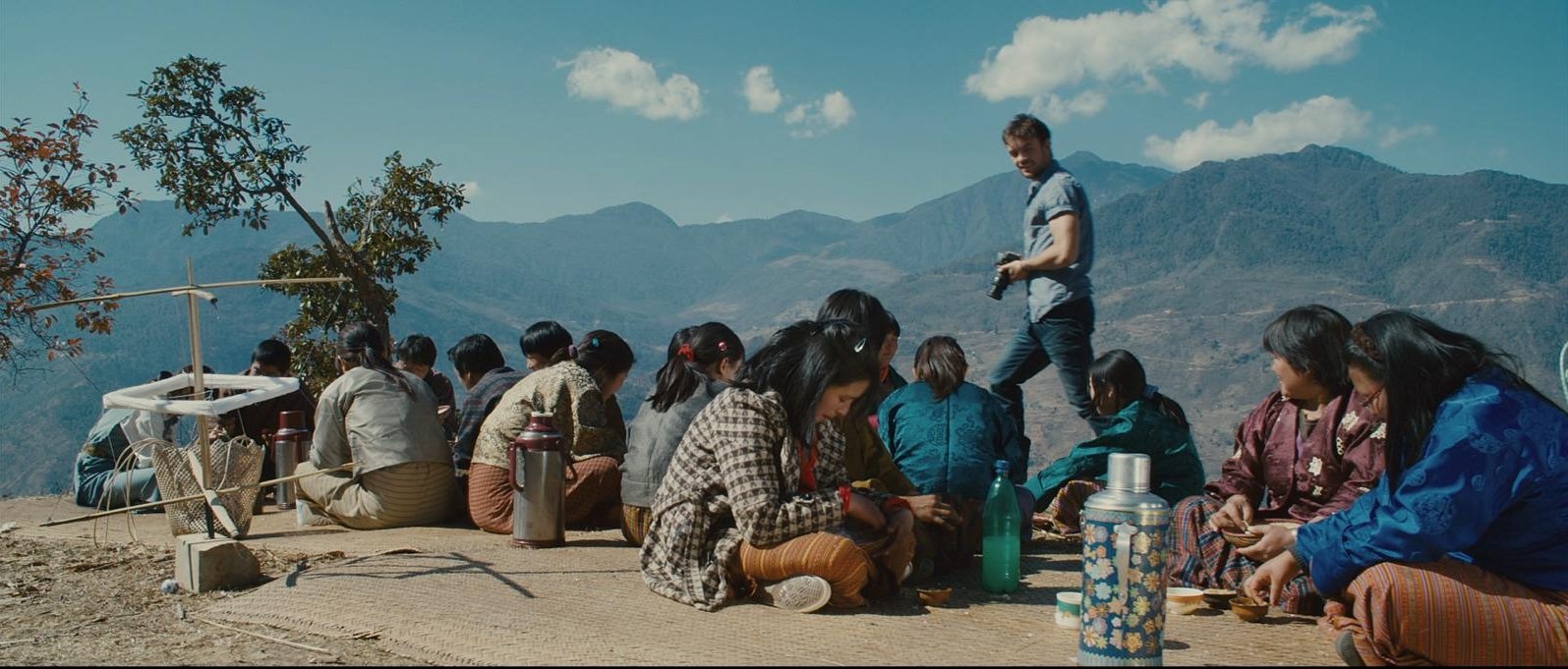 Karma Deki's film crew gathered with Bhutanese villagers on a mountain overlook in the Himalayas